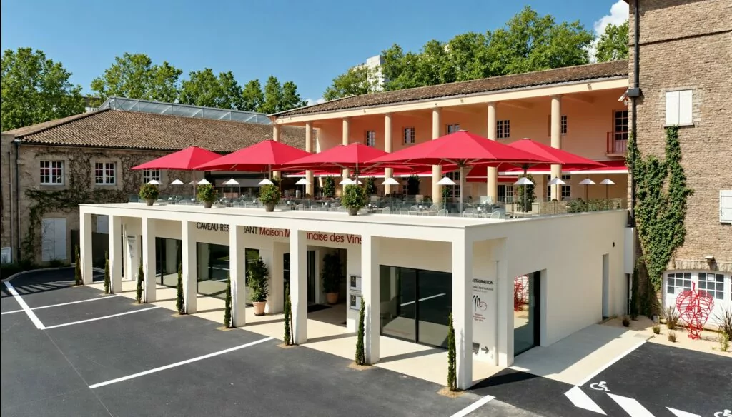 La façade et sa terrasse aux parasols rouges